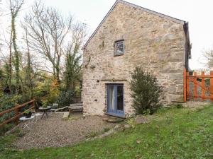 a stone house with a blue door in a yard at Castle Mill in Newport Pembrokeshire