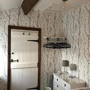 a room with a door and a wall with wallpaper at Mistletoe Cottage in Foulridge