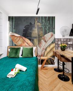 ein Schlafzimmer mit einem grünen Bett und einem Tisch in der Unterkunft Jacuzzi & Bike Apartment, Krakow in Krakau
