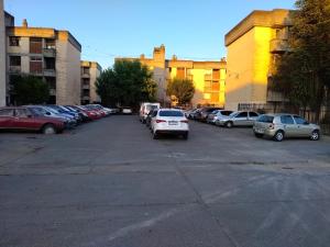 薩爾塔的住宿－Temporario Salta，停车场,停车场的汽车停在大楼前