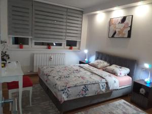 - une chambre avec un lit, un bureau et une table sidx sidx dans l'établissement Trosoban apartman Sarajevo, Ilidza centar, à Sarajevo