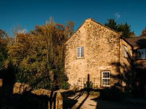 an old brick building with a fence in front of it at The Groomsmen in Clitheroe