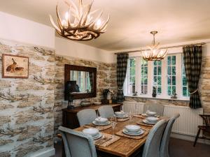 a dining room with a wooden table and chairs at The Lodge in Clitheroe