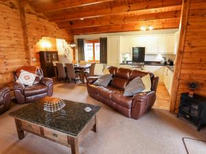 a living room with leather couches and a table at Avocet Lodge in Lincoln