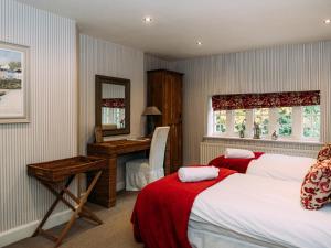 a bedroom with two beds and a desk and a mirror at The Lodge in Clitheroe