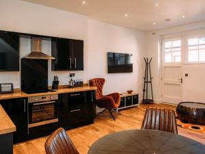 a kitchen with black cabinets and a table and chairs at The Gardener in Clitheroe