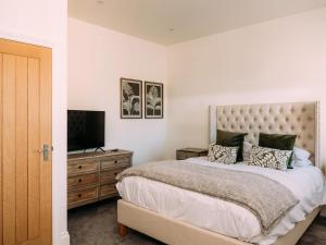 a bedroom with a bed and a television on a dresser at The Gardener in Clitheroe