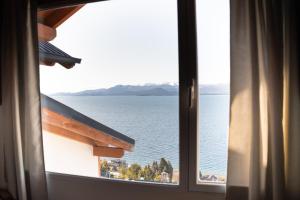 einen Blick auf das Wasser aus dem Fenster in der Unterkunft Departamento Las 3 Marías in San Carlos de Bariloche + 5 Fotos