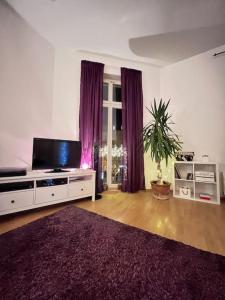 ein Wohnzimmer mit einem Flachbild-TV und einem Sofa in der Unterkunft «Breakfast at Tiffany's» in Leipzig