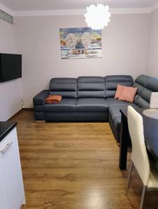 a living room with a blue couch and a table at Apartament Warmińska in Barczewo