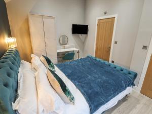 a bedroom with a large bed with a blue blanket at Honeysuckle in Hull
