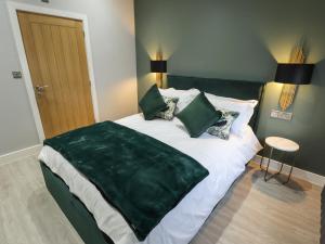 a bedroom with a large green blanket on a bed at Willow in Hull