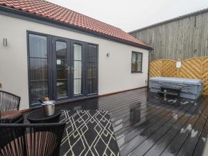 a large deck with black sliding glass doors at Willow in Hull