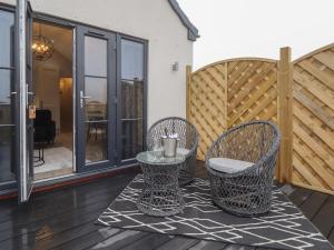 un patio con 2 sillas y una mesa en una terraza en Jasmine, en Hull