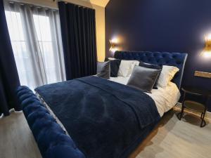 um quarto com uma cama azul e um cobertor azul em Wysteria em Hull