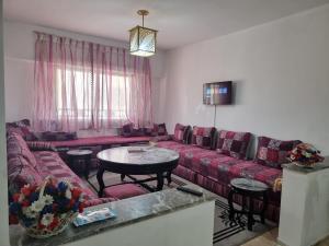 uma sala de estar com sofás vermelhos e uma mesa em Spacious 2 BR near mausolée med V, 1min walk tram. em Rabat
