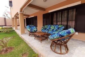 3 chaises et une table sur une terrasse dans l'établissement villa luxueuse et meublée plus de 280 m², à Antananarivo