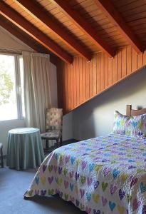 ein Schlafzimmer mit einem Bett und einem Tisch und einem Fenster in der Unterkunft Departamento Las 3 Marías in San Carlos de Bariloche
