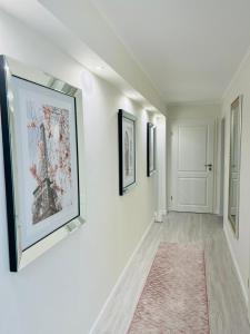 a hallway with paintings on the walls and a rug at LeCiel Maison Lily in Bad Lauterberg