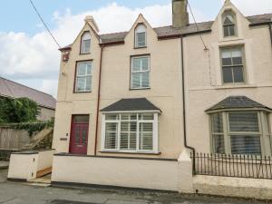 a large white house with a red door at Glanffrwd - Nefyn in Pwllheli