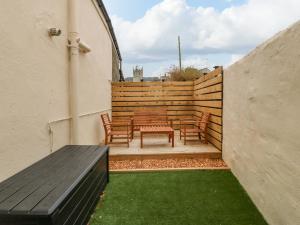 a patio with a table and chairs and a fence at Glanffrwd - Nefyn in Pwllheli