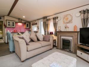 uma sala de estar com um sofá e uma lareira em Nordene em Cockermouth