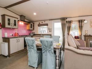 a kitchen and living room with a table and chairs at Nordene in Cockermouth