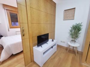 um quarto com uma televisão num armário branco em Castrelos, Vigo, diseño em Vigo