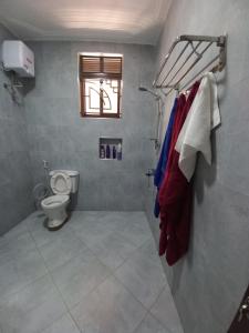 a bathroom with a toilet and a towel rack at nostiQ homes in Kampala
