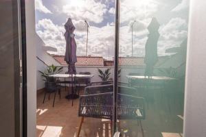 Una vista de un balcón con una mesa y una sombrilla. en Feel Nazaré - Batalha 124, en Nazaré