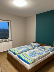 a bedroom with a bed with pillows and a window at Apartamenty Polna 60 in Żory