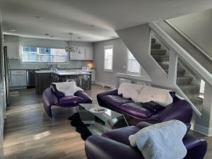 a living room with purple furniture and a kitchen at Portside Condos #3 - Grand Haven in Grand Haven