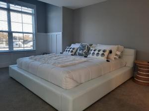 1 dormitorio con 1 cama blanca grande con almohadas en Portside Condos #3 - Grand Haven, en Grand Haven