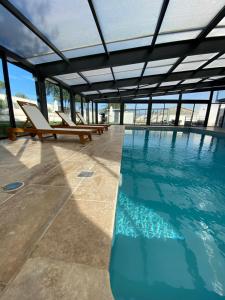 a swimming pool with lounge chairs and a building at O Bain Soleil in Bourg-Saint-Andéol