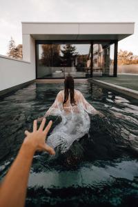 Comme chez Lore - villa 2pers - piscine chauffée في نامور: A woman swimming in a pool in a house