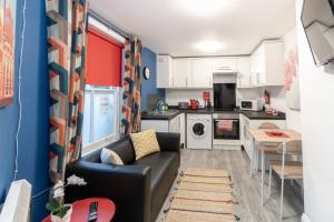 a living room with a couch and a kitchen at Beside The Seaside - By My Getaways in Brighton & Hove