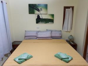 - un lit avec 2 oreillers verts dans l'établissement Cabañas Selva Verde, à Puerto Iguazú