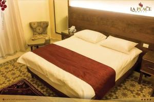 um quarto de hotel com uma cama e uma cadeira em La Place Hotel em Zahlé