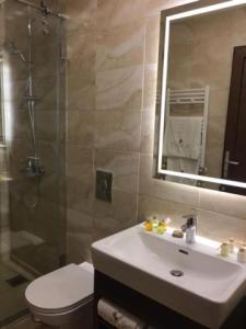 a bathroom with a sink and a toilet and a mirror at La Place Hotel in Zahlé