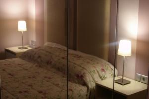 1 dormitorio con 1 cama y 2 mesas con lámparas en room "butterfly" in a neoclassical house, en Kastoria