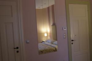 a mirror on a wall in a room with a bed at room "butterfly" in a neoclassical house in Kastoria