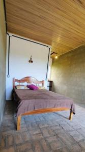 a large bed in a room with a wooden ceiling at EcoMar - Pousada de Experiência in Barra de São Miguel