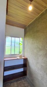 Cette chambre dispose d'une fenêtre et d'un plafond en bois. dans l'établissement EcoMar - Pousada de Experiência, à Barra de São Miguel