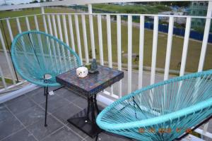 two blue chairs and a table on a balcony at SMDC Wind Loft Bedroom 101 Facing Amenities with WIFI and Parking in Tagaytay