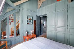 トロワにある2 bedrooms appartement with enclosed garden and wifi at Troyesの青い壁のベッドルーム1室、ベッド1台、テーブルが備わります。