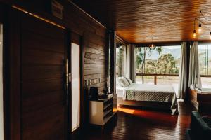 a bedroom with a bed and a window at Recanto- Pousada Cachoeira da Neve in Urubici