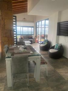 sala de estar con mesa, sillas y sofá en Palmaire Villa 59, en San Gil