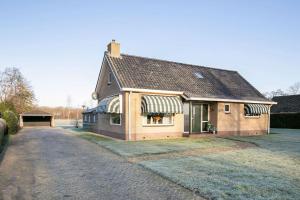 a large house with a driveway in front of it at Knus appartement aan bosrand in Hornsterzwaag