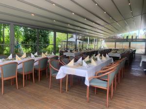 a restaurant with white tables and chairs and windows at Schweier Krug in Schwei