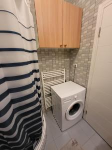 a small bathroom with a washing machine and a toilet at Apartman VM in Bjelašnica
